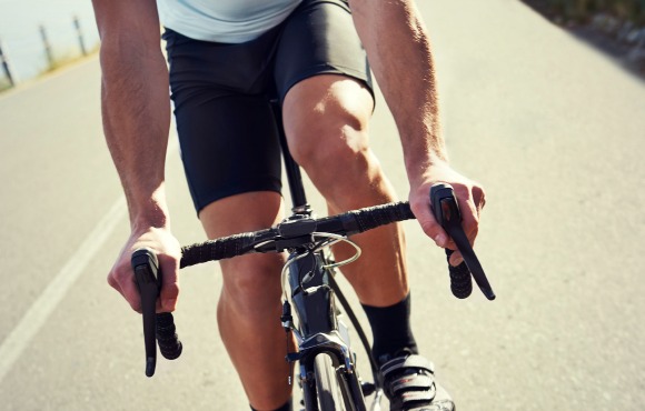 Cropped shot of a sportsman cycling on a road with a scenic view